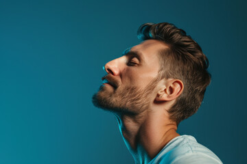 A close up of a man with beard and closed eyes looking to a side