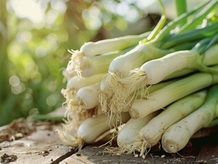 Wall Mural - A bunch of green onions are piled on top of a wooden table. The onions are fresh and ready to be used in a meal