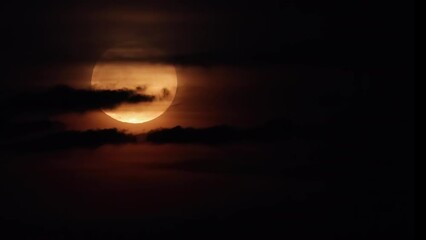 Wall Mural - Full Moon behind black clouds. Clouds passing by the Moon create an spooky feeling like thriller and horror films. Real footage of the night sky