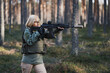 © Dmitri - A military girl takes aim from a modern assault rifle in the forest.
