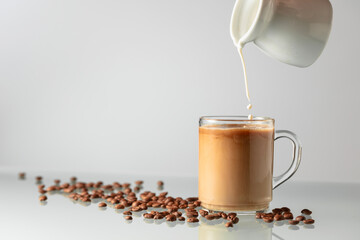 Wall Mural - Pouring milk in black coffee.