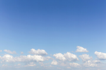 Wall Mural - Blue sky background texture with copyspace. White fluffy cumulus clouds against blue sky, heaven