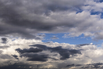 Wall Mural - Epic Dramatic storm dark grey cumulus rain clouds against blue sky background texture, thunderstorm