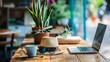 © Yaroslav Herhalo - Freelancer?s wooden desk arranged for a productive morning with technology and green plants.