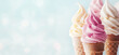 © juliasudnitskaya - Creamy vanilla raspberry ice cream in waffle cones against light blue background. Yummy summer dessert, pastel colors, banner.