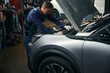 © Svitlana - Man repairing machine in the car service center