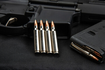 Wall Mural - Close-up of .223 carbine cartridges. Loaded weapon clip. Weapons in the back