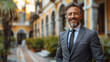 © ML - Handsome businessman in suite smiling and standing on the street in Europe