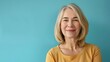© Bijac - friendly middleaged blonde woman smiling at camera portrait on blue background highresolution photo