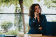 © qunica.com - Confident businesswoman in a suit having a phone conversation while working at an outdoor cafe, representing professional and modern work lifestyle