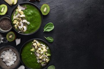 Wall Mural - Delicious and healthy green smoothie bowls made with fresh ingredients spinach, avocado, kiwi, apple, coconut milk, and chia seeds top view. Vegan and nutritious breakfast concept, copy space