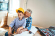 © Dragana Gordic - Grandpa and grandson enjoy together at grandpa's kitchen.  Serious nice positive grandfather and grandson sitting at the table and looking at the drill while working together