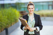 © Alliance - Portrait of happy modern woman worker near office building