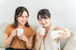 © buritora - カフェで友達と自撮り・セルフィーをするアジア人女性