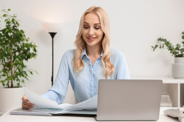 Wall Mural - Happy secretary working with documents at table in office