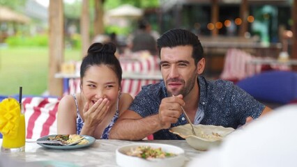 Wall Mural - Group of Man and woman friends have fun meeting party having lunch together at boutique beach restaurant. People enjoy eating and sharing meal with talking together at cafe on summer holiday vacation.