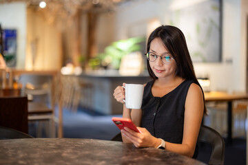 Wall Mural - Woman in the coffee shop with her phone