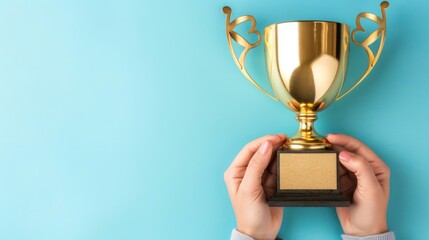 Winner, Golden Cup. A person holds a gold trophy with a blank plaque on a blue background