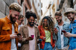 © luciano - Group of young people using smart mobile phone device outside in city street- Young student college university people addicted to social media - Modern technology concept