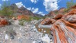 © Mikus - A scene of a rocky expanse, populated by rocks and vegetation in the foreground Behind this lies a distant mountain range, framed by a blue sky dotted with clouds