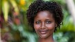 © Mikus - A close-up of a person smiling, with a bush in the background beyond her, and a green bush visible behind
