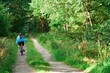 © AlexGo - Young woman biking on country road