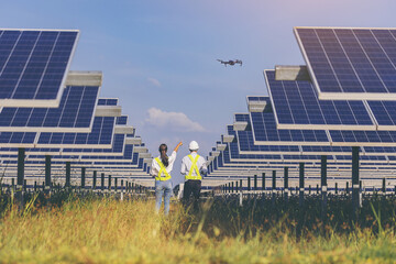 Electrical and instrument technician flying drone for temperature checking and maintenance electrical system at solar panel field.