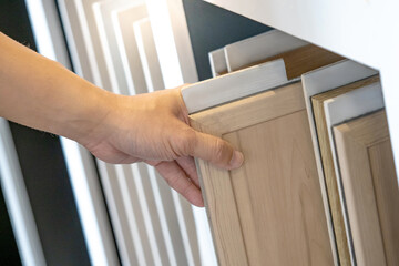 Wall Mural - designer hand choosing and picking wooden board with frame for wall partition material design. light