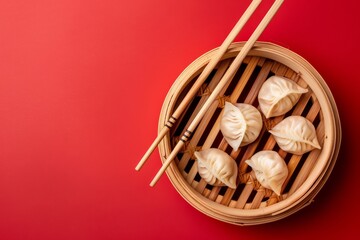Wall Mural - Traditional Chinese steamed dumplings in bamboo steamer with wooden chopsticks on red background, close up, top view. Asian dumplings as dim sum snack or lunch, space for text .