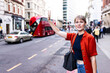 © Westend61 - Smiling woman calling for cab standing at street