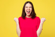 © ViDi Studio - Young excited happy cool woman wear pink t-shirt casual clothes doing winner gesture celebrate clenching fists say yes isolated on plain yellow orange background studio portrait. Lifestyle concept.