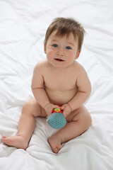 Canvas Print - Cute baby boy with toy sitting on bed