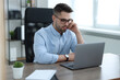 © New Africa - Young programmer working with laptop in office