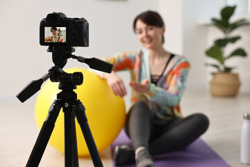 Poster - Happy sports blogger recording fitness lesson at home, focus on camera