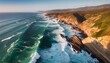 © CoffeeeCraze - Aerial view of dramatic coastal cliffs with rugged rock formations, pounded by powerful ocean waves under a golden sunset.