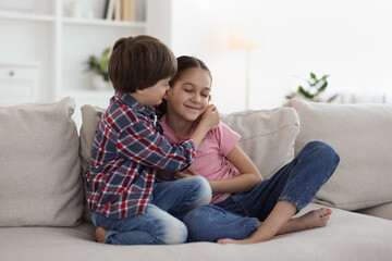 Poster - Happy brother and sister spending time together on sofa at home