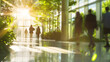 © Prasanth - Blurred background of people walking in a modern office building with green trees and sunlight , eco friendly and ecological responsible business concept image with copy space