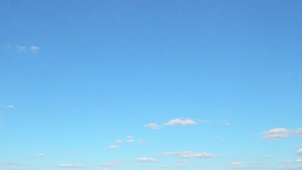 Wall Mural - White cumulus clouds slowly move in the blue summer sky. Background with some clouds and empty space for information.