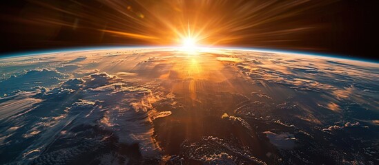 sunrise view of the planet earth from space with the sun setting over the horizon.