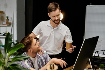 Wall Mural - Two men in casual attire studying data on a computer screen in an office setting.