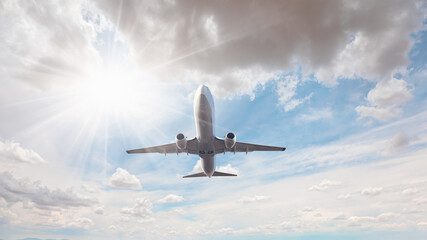 Wall Mural - White passenger airplane flying in the sky amazing clouds in the background - Travel by air transport