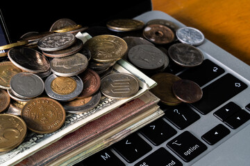 Wall Mural - Pile of various coins on the stack of various banknotes