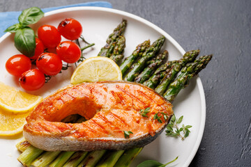 Wall Mural - Grilled salmon steak over grilled asparagus, a delicious meal