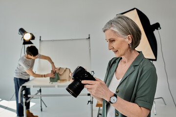 A middle-aged woman holds a camera in a modern photo studio setting.