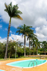 Children's and adult pool. Trees. Lampposts. Cloudy sky. Decoration.