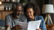 © bird_saranyoo - Happy black couple reviewing their life insurance policy documents