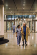 © Maskot - Female doctor walking with senior patient in lobby of hospital