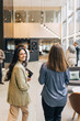 © Maskot - Smiling businesswoman walking with female entrepreneur in lobby at convention center