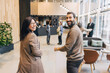 © Maskot - Portrait of happy male and female delegates walking in lobby at convention center