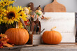 © Deborah - Autumn background.  Sunflowers, pumpkins, scarecrows in a rustic kitchen with wooden counter and cutting boards, bread board